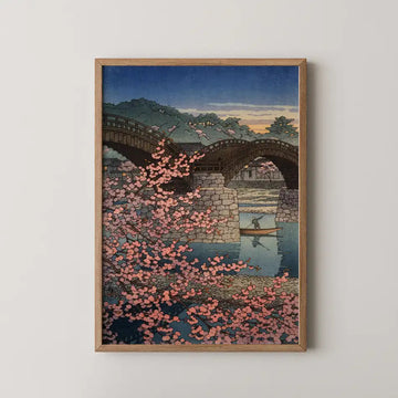 Hasui Kawase woodblock print of Evening Spring at Kintai Bridge, cherry blossom in silhouette as a boatman poles beneath the arches at dusk.