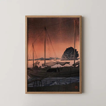 Hasui Kawase woodblock print of Hayama in Iyo, fishing boats silhouetted at anchor against a deep orange sunset sky beside a wooded islet.