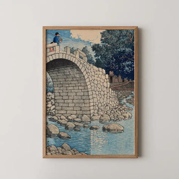 Hasui Kawase woodblock print of Kanahama, Hizen, a stone arch bridge over a turquoise river with a fisherman casting from its parapet.