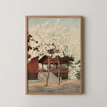 Hasui Kawase woodblock print of Kiyomizu Hall in Ueno, a red temple pavilion framed by a cherry tree in full white blossom.