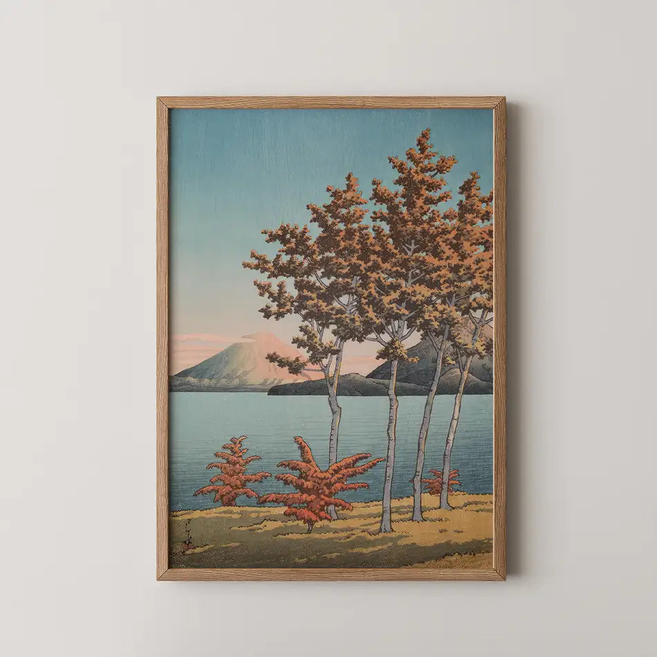 Hasui Kawase woodblock print of Lake Toya in Hokkaido, golden autumn trees on the shore with a distant mountain across the water.
