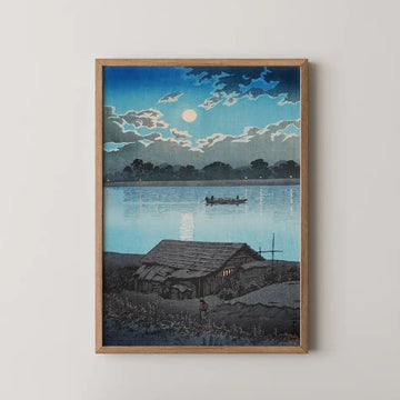 Hasui Kawase woodblock print of Moon over Ara River, a riverside hut and rowing boat beneath a full moon reflected on calm water.