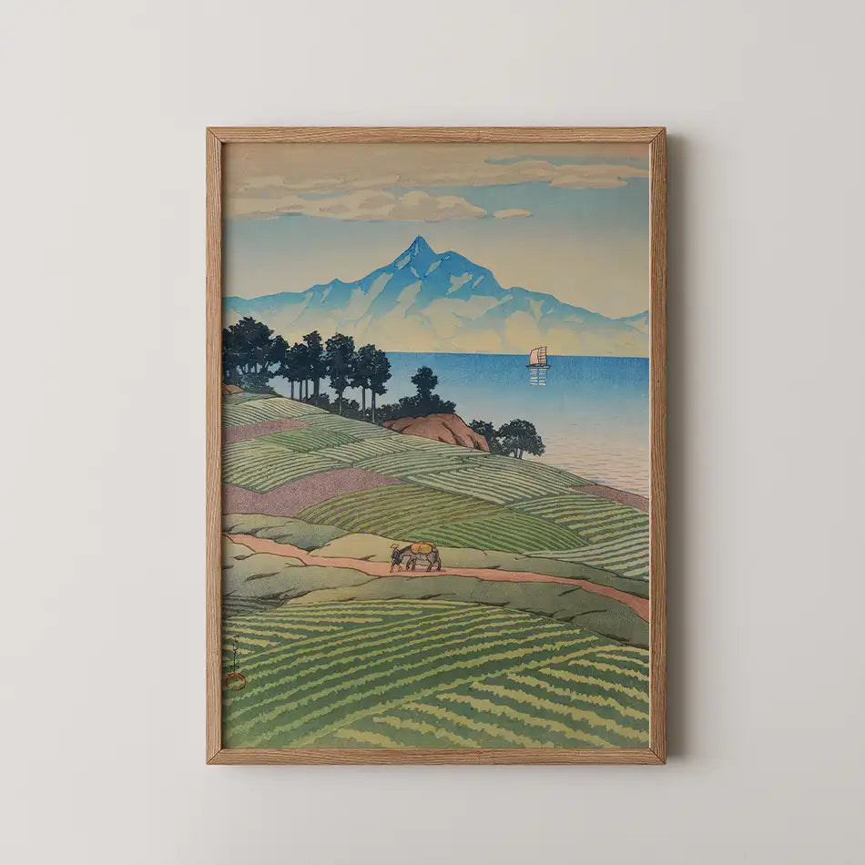 Hasui Kawase woodblock print of Mt. Unzen from Amakusa, terraced fields and a pack horse above the sea with a distant mountain peak.