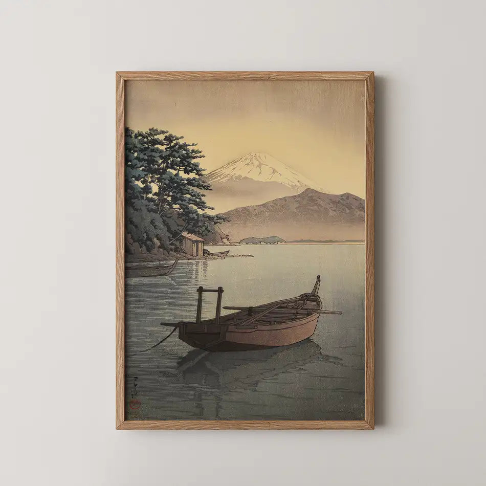 Hasui Kawase woodblock print of Nagahama Beach in Mito, a wooden fishing boat at anchor with a snow capped mountain across the golden bay.