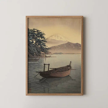 Hasui Kawase woodblock print of Nagahama Beach in Mito, a wooden fishing boat at anchor with a snow capped mountain across the golden bay.