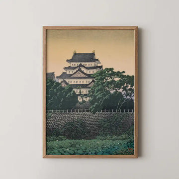 Hasui Kawase woodblock print of Nagoya Castle, its tiered white keep and dark roofs rising above green trees at dusk.