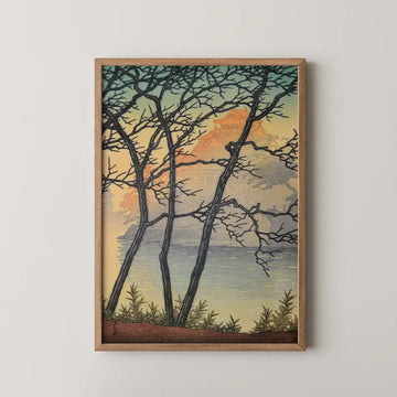 Hasui Kawase woodblock print of Okayama Castle in morning, its gold lit tower seen through bare branches across a still river at sunrise.