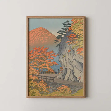 Hasui Kawase woodblock print of Saruiwa, Shiobara, a grey stone cliff with a leaning pine above a wooden bridge surrounded by autumn maple.