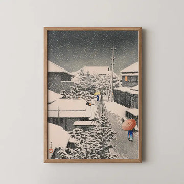 Hasui Kawase woodblock print of a snow covered street at Daichi at night, two figures walking home under a red umbrella as snow falls.