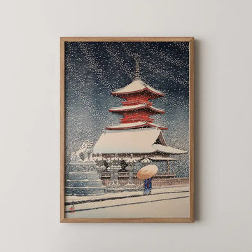 Hasui Kawase woodblock print of Snow at Toshogu in Ueno, a red pagoda under heavy snowfall as a figure walks past stone lanterns at night.