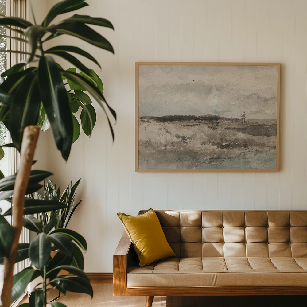 Painting in a light wooden frame depicting a serene landscape with soft gray and blue tones, hanging on a wall above a modern tan sofa with a yellow pillow, surrounded by indoor plants.