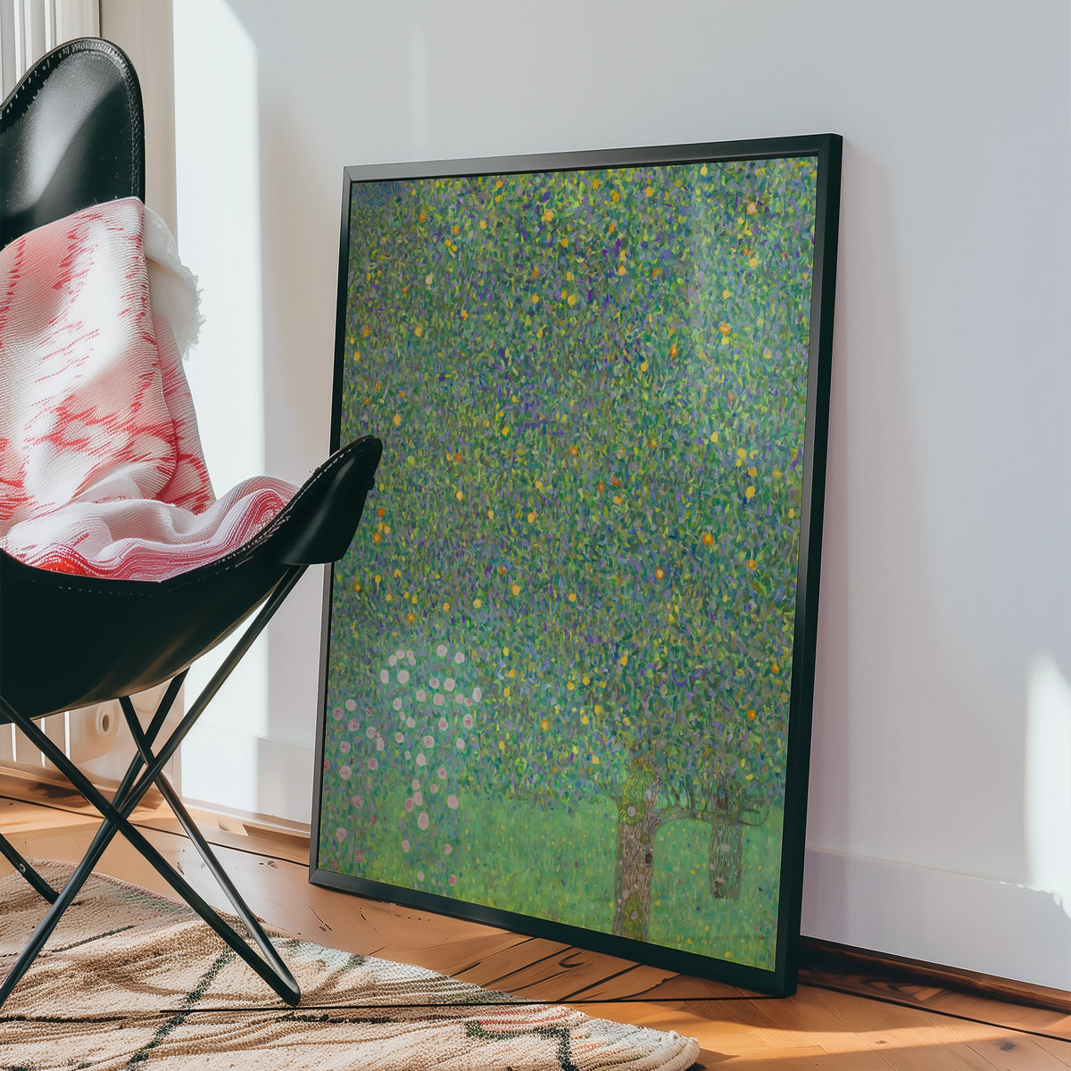 Framed colorful painting leaning against a wall next to a black chair and a patterned rug.