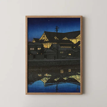 Framed painting of a serene night scene featuring traditional architectural buildings reflecting in water under a starry sky.