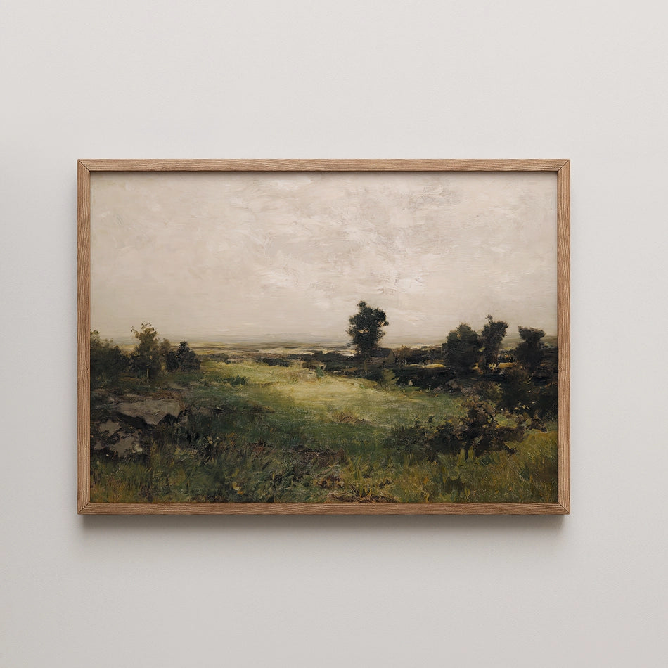 Framed landscape painting featuring a serene green field under a cloudy sky with distant trees.