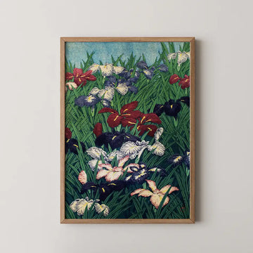 Framed painting of colorful irises in a lush green field with a blue sky backdrop.