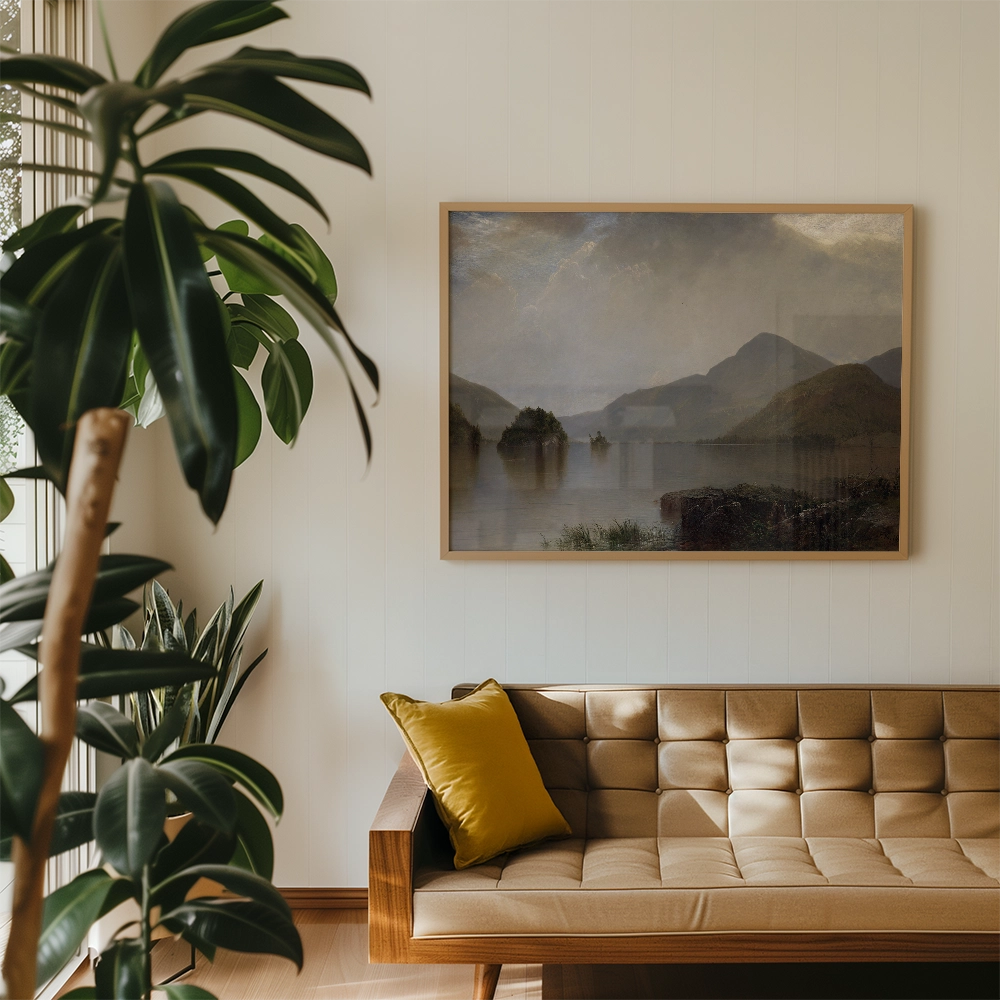 A tranquil landscape painting featuring mountains and a reflective lake, framed and displayed in a modern living room setting with greenery and a brown tufted sofa.