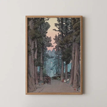 Framed painting of a serene forest path with towering trees and a colorful sunset in the background.