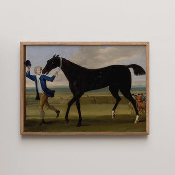 Painting of a man in a blue jacket leading a black horse in a landscape, framed in light wood.