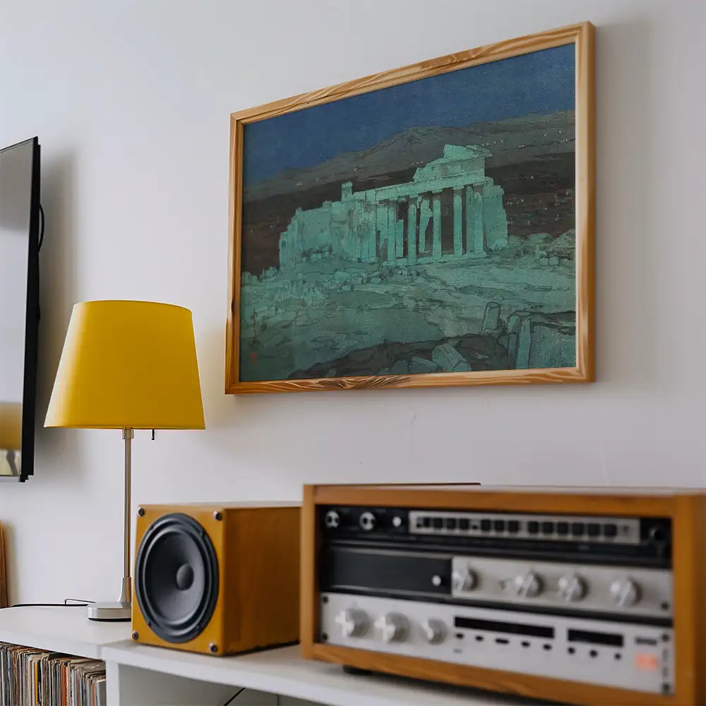 Framed painting of ancient ruins displayed on a wall, with a yellow lamp and vintage audio equipment in the foreground.