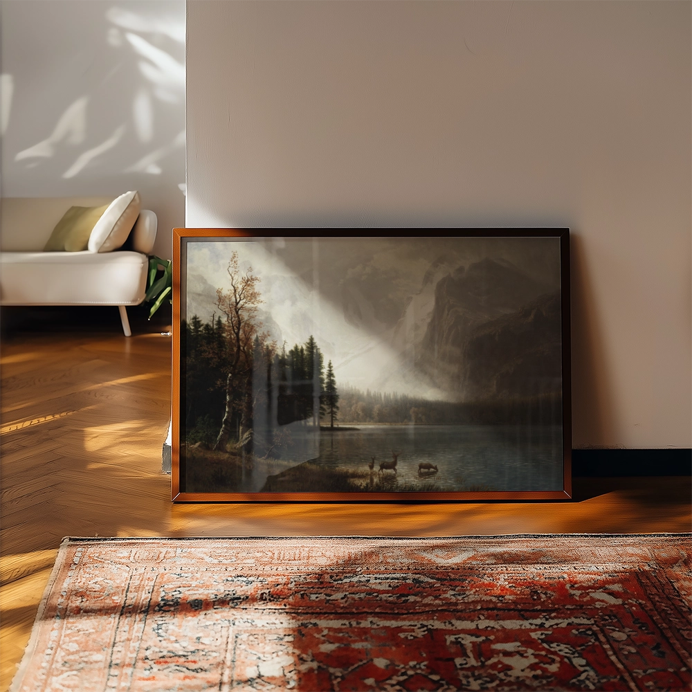 Framed painting of a serene landscape featuring a lake, mountains, and trees, leaning against a wall in a modern interior setting.