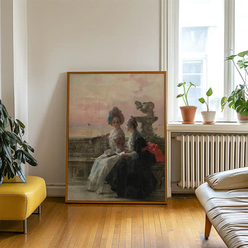 Painting of two elegantly dressed women sitting by the sea, displayed in a modern living room setting with plants and warm wooden floors.