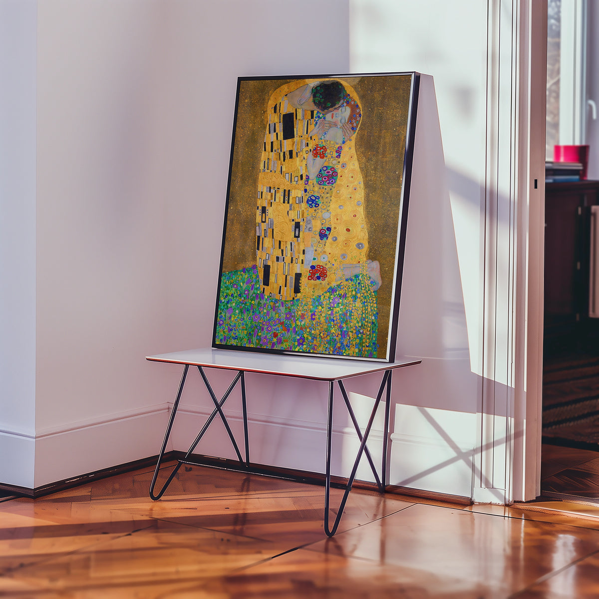 Framed painting of a couple embracing in a colorful and intricate design, displayed on a stylish table in a well-lit interior.