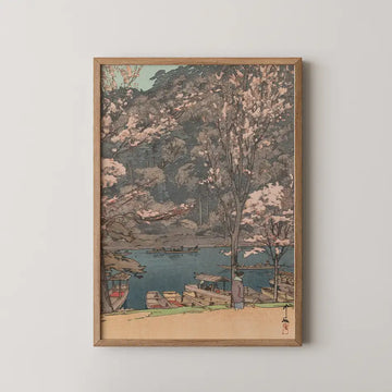 Framed painting of a serene landscape depicting cherry blossom trees by a river with boats, showcasing soft pastel colors.