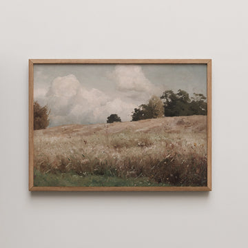 Framed landscape painting of a grassy field under a cloudy sky.