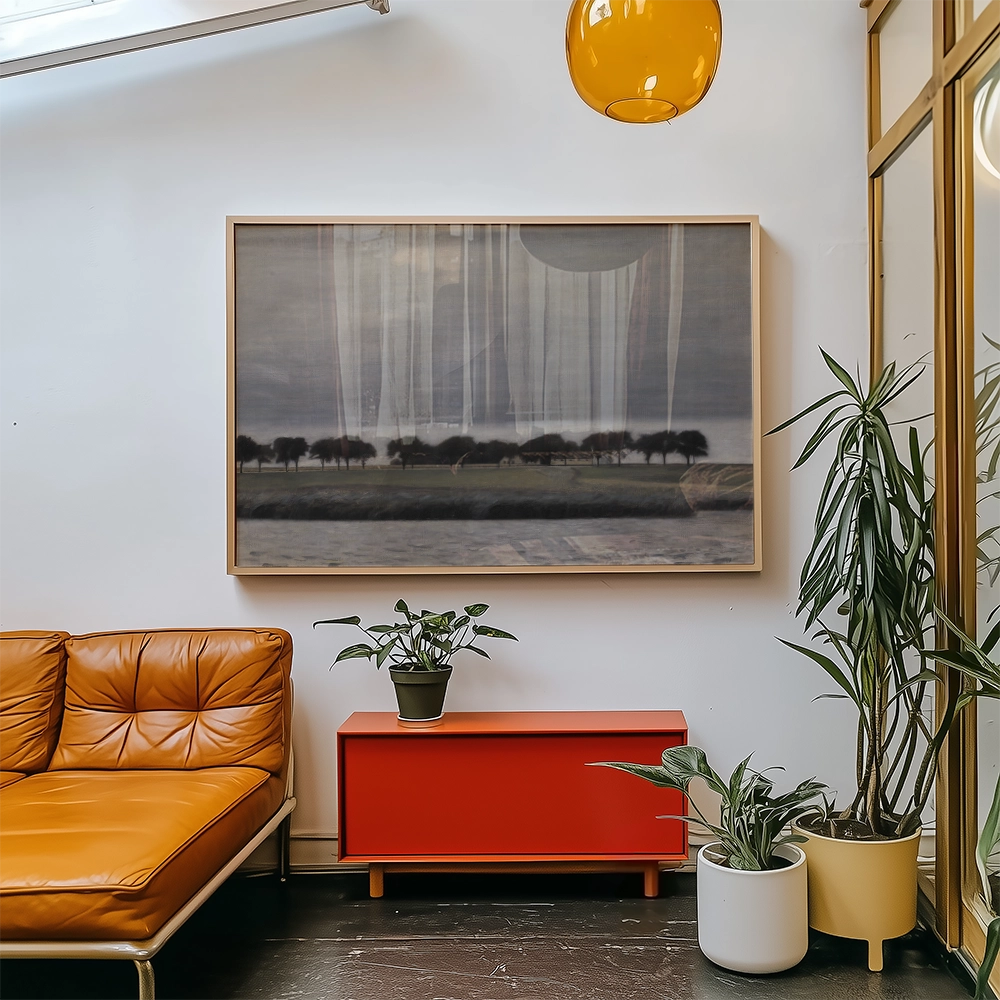 Painting of a landscape with trees and water, displayed in a modern living room with an orange couch and potted plants.
