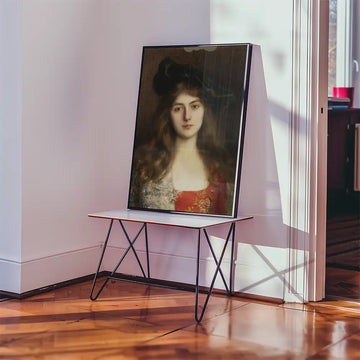 Painting of a woman with long hair and a red dress displayed on a modern table in a bright room.