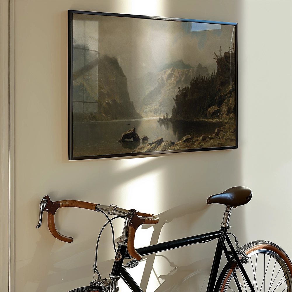 Painting of a serene landscape with mountains and a river, framed and hung on a wall next to a vintage bicycle.
