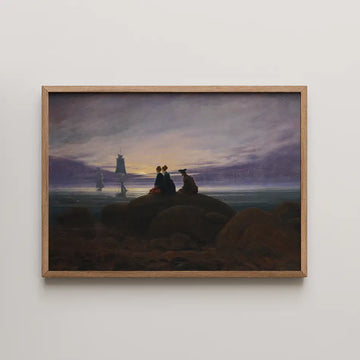 Silhouetted figures on rocks at sunset with sailing ships in the background, framed painting.
