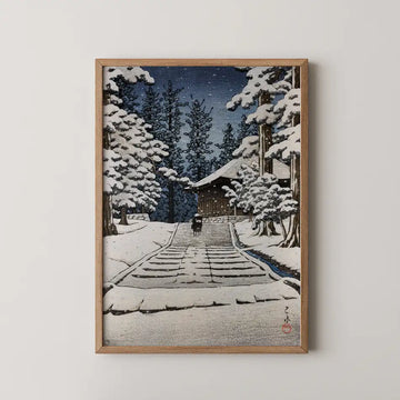 Framed painting of a winter landscape featuring a chapel surrounded by snow-covered trees and a person walking on a path.