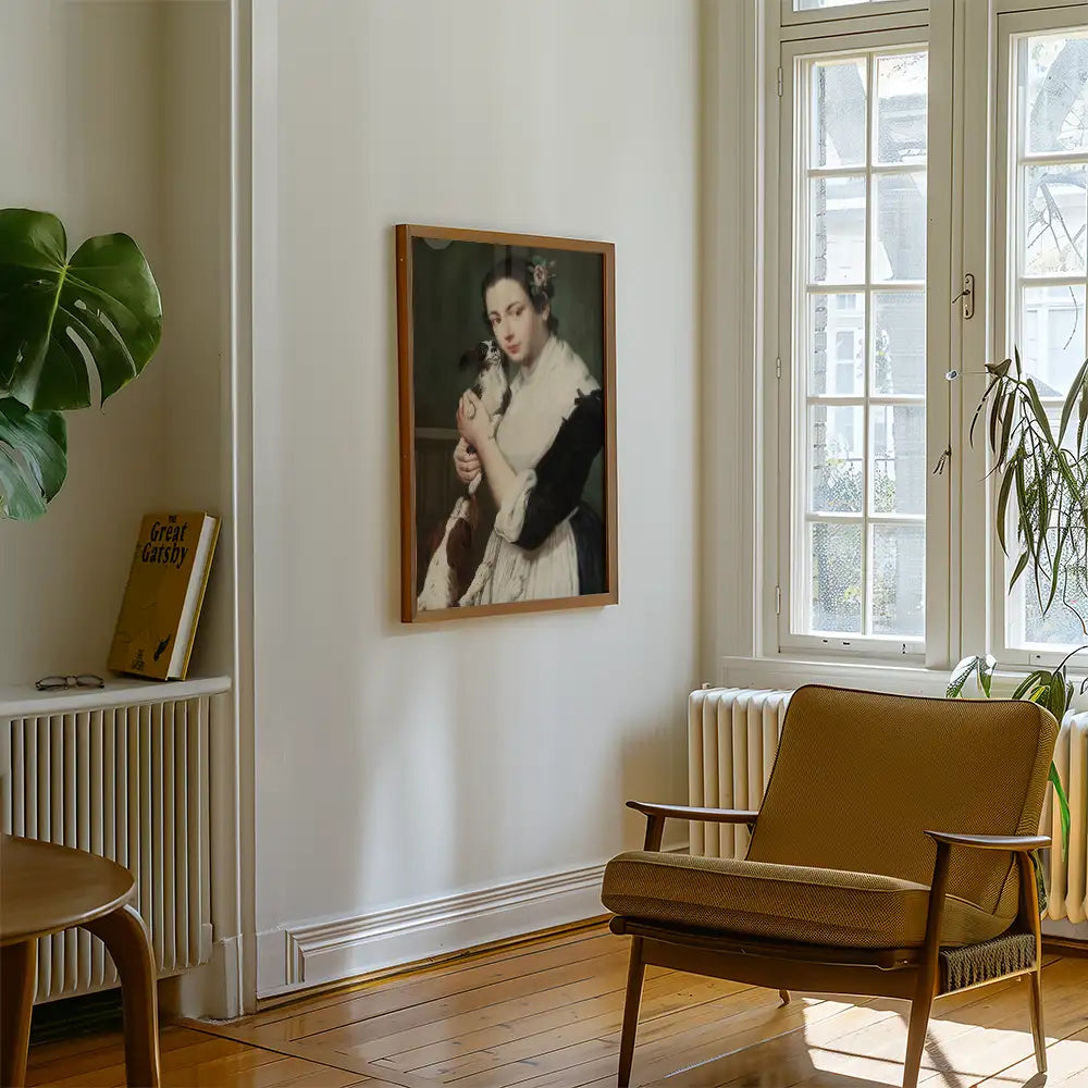 Painting of a woman holding a dog, framed and hung on a wall in a bright, modern interior with a chair and green plants.