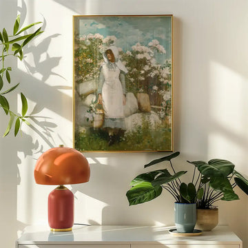 A vintage painting of a woman in a white dress holding a basket, surrounded by flowers, hanging on a wall next to a contemporary lamp and potted plants.