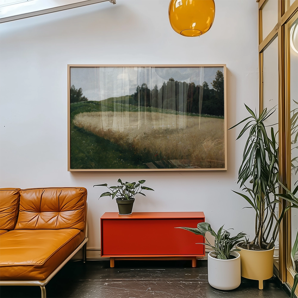 Painting of a serene landscape featuring rolling hills and a field of wheat, displayed in a modern living room setting with an orange couch and decorative plants.