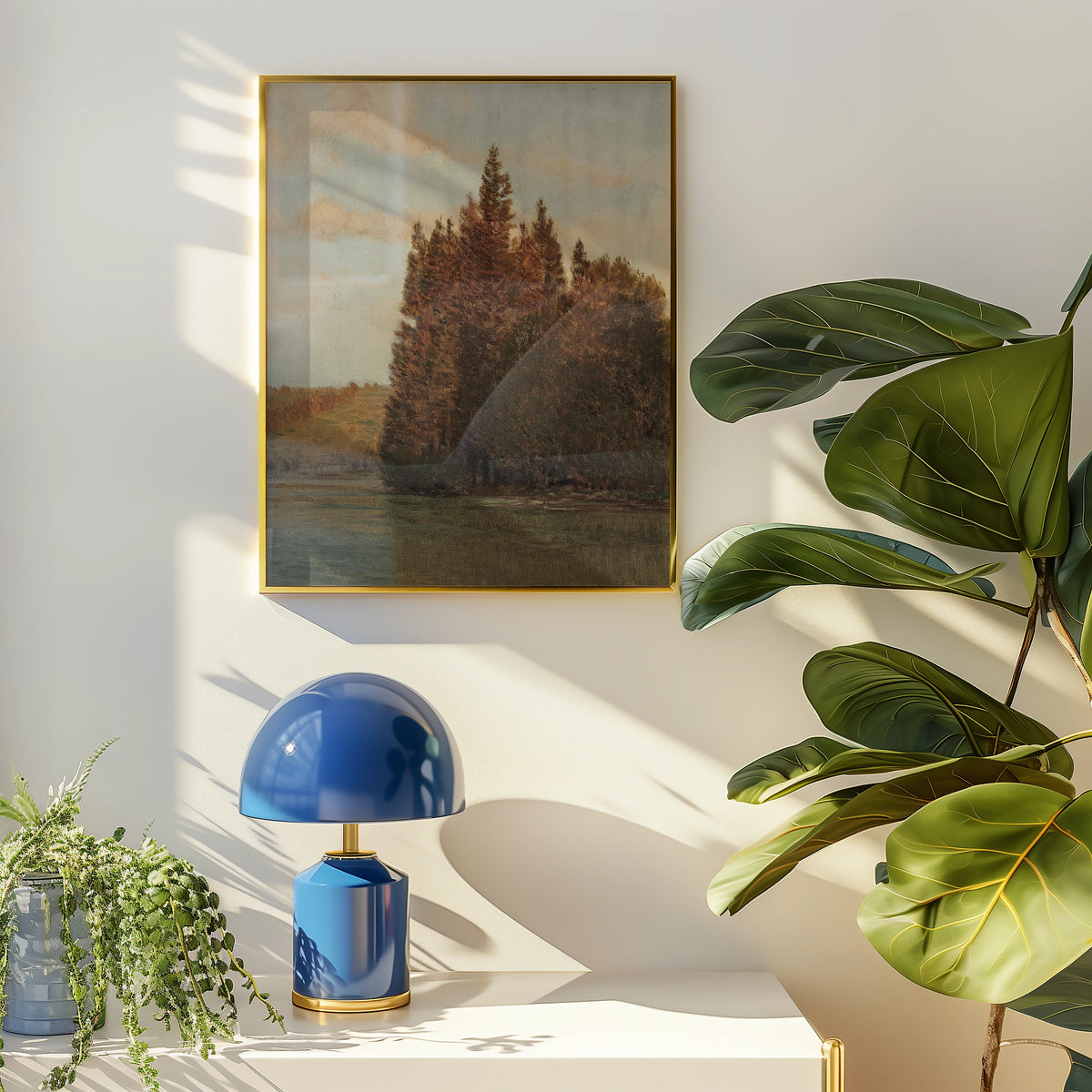 Painting of a serene landscape featuring trees beside a calm body of water, framed in gold, displayed on a softly lit wall with a stylish blue lamp and lush green plants nearby.