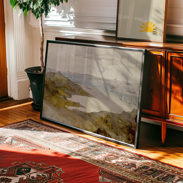 Painting of a serene coastal landscape leaning against a wooden console table, with natural light casting shadows in a warm room setting.