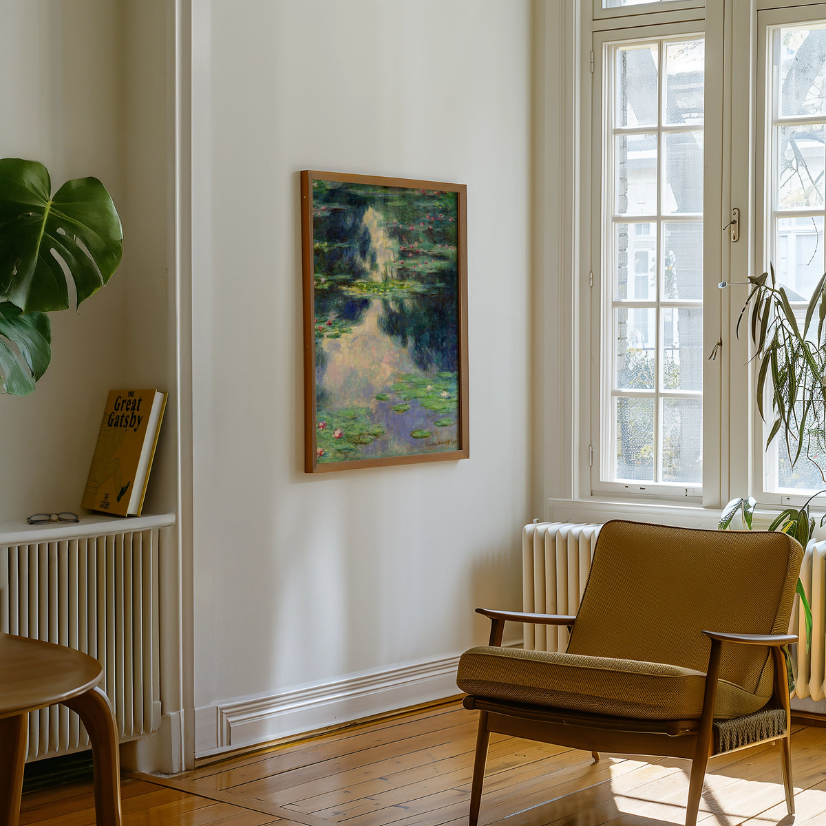 Painting of water lilies hanging on a white wall, next to a brown chair and a bookshelf with a copy of "The Great Gatsby."
