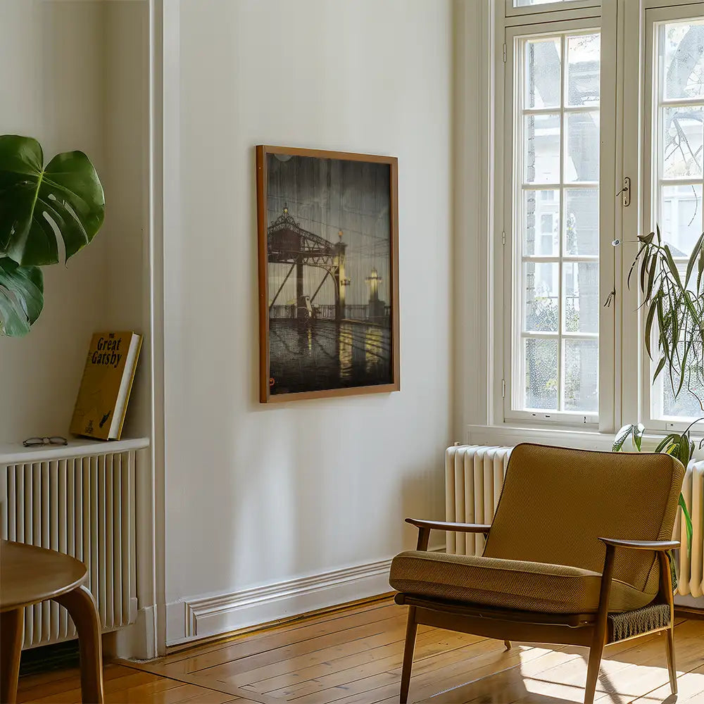 Painting of a waterfront scene framed on a wall in a bright, stylish room featuring a plant, a chair, and a book.