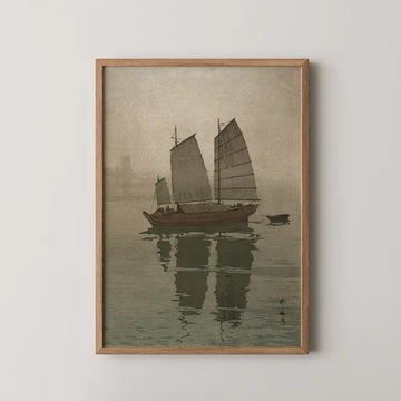 Framed painting of a boat with sails on water, reflecting its image, in muted tones.