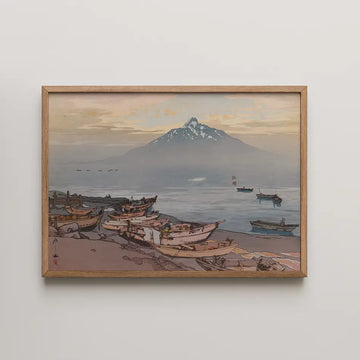Framed painting of a serene coastal scene with boats on the shore and a mountain in the background during sunset.