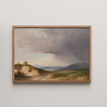 Karol Marko landscape painting titled Hilly Landscape with Cloudy Skies, showing a dirt road through sunlit hills before distant blue mountains under a darkening sky.