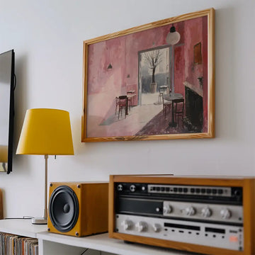 Modern reprint of a famous painting featuring a pink interior with empty chairs and a tree outside, displayed above a vintage audio setup and yellow lamp.