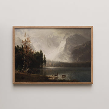 Framed painting of a serene mountainous landscape with a lake, forest, and deer, conveying a tranquil natural scene.