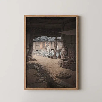 Framed painting depicting two figures in traditional attire working in a rustic outdoor setting with wooden structures and stone pathways.