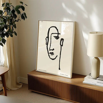 Modern minimalist poster of a famous painting featuring a linear abstract face design, displayed in a stylish living room setting with natural light and decorative elements.