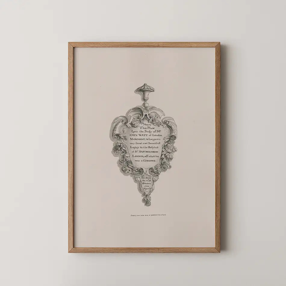 Framed vintage-style artwork featuring an ornate design with written text about John Want of London, displayed against a neutral background.