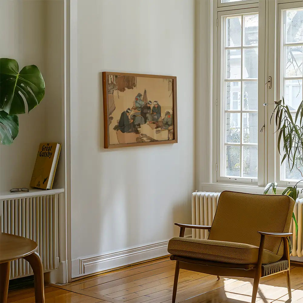 Painting of figures sitting at a table, framed and displayed on a white wall, next to a cozy chair and a plant in a bright, airy room.