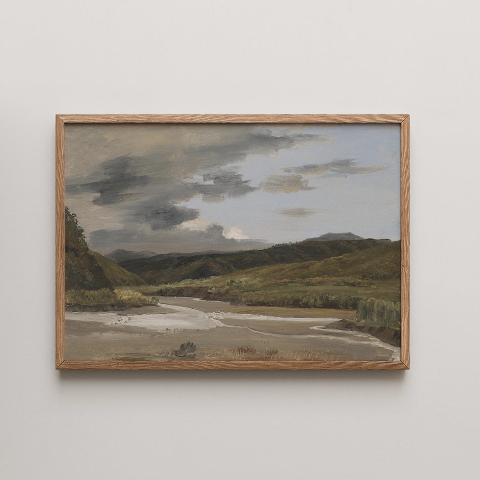 Framed painting of a serene landscape featuring rolling hills, a flowing river, and a cloudy sky.